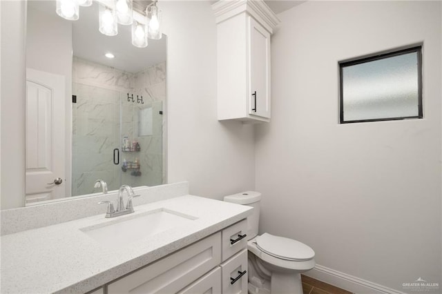 bathroom with vanity, toilet, and a shower with door