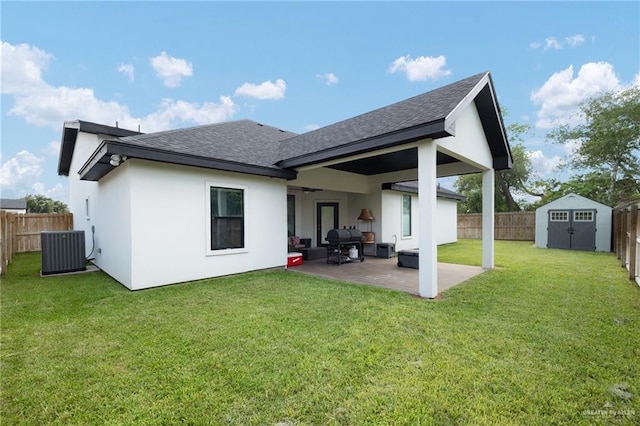 rear view of house featuring a storage shed, a patio, a lawn, and central air condition unit