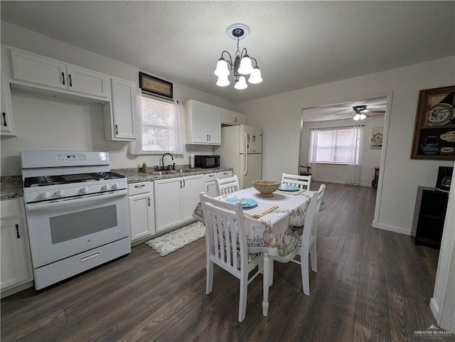 kitchen featuring hanging light fixtures, dark hardwood / wood-style floors, white cabinets, and white appliances