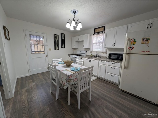 dining area featuring dark hardwood / wood-style floors, sink, a textured ceiling, and a notable chandelier