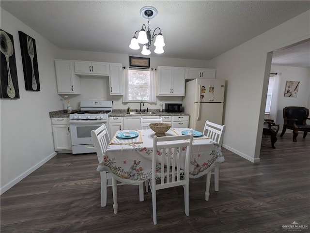 kitchen featuring pendant lighting, white cabinetry, sink, a notable chandelier, and white appliances