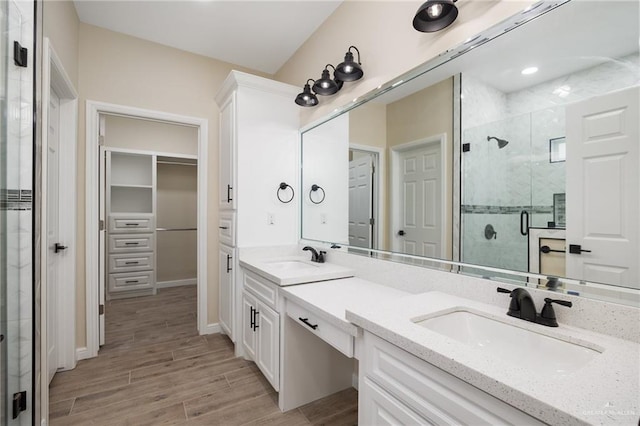 bathroom featuring hardwood / wood-style floors, vanity, and a shower with shower door