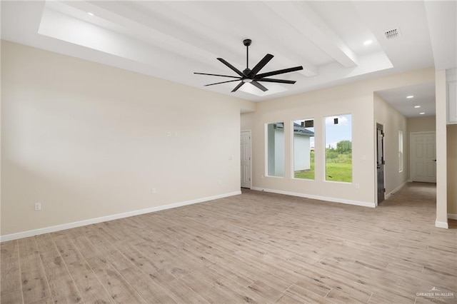 spare room with ceiling fan, beam ceiling, and light wood-type flooring