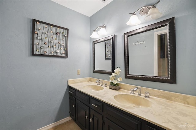 full bathroom featuring double vanity, baseboards, and a sink