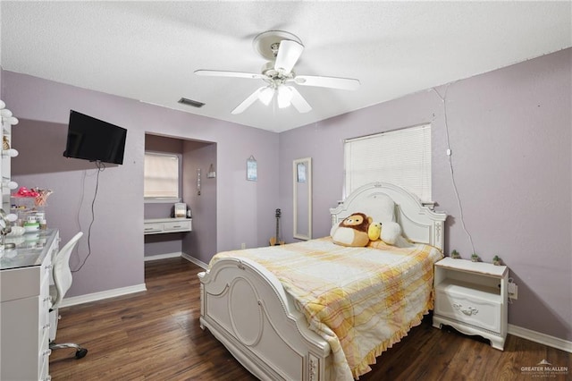 bedroom with baseboards, dark wood finished floors, and visible vents