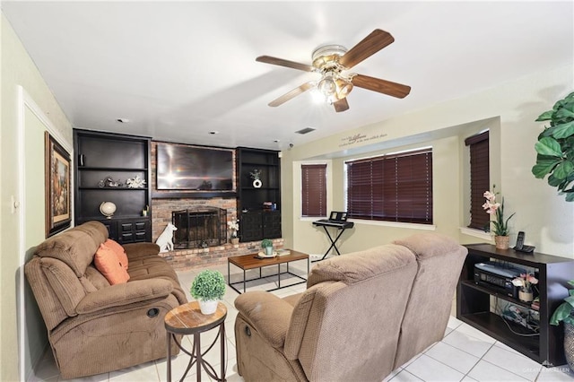 tiled living room featuring visible vents, a ceiling fan, built in shelves, and a fireplace