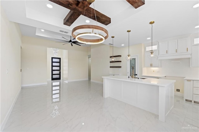 kitchen with pendant lighting, sink, a kitchen island with sink, coffered ceiling, and white cabinets