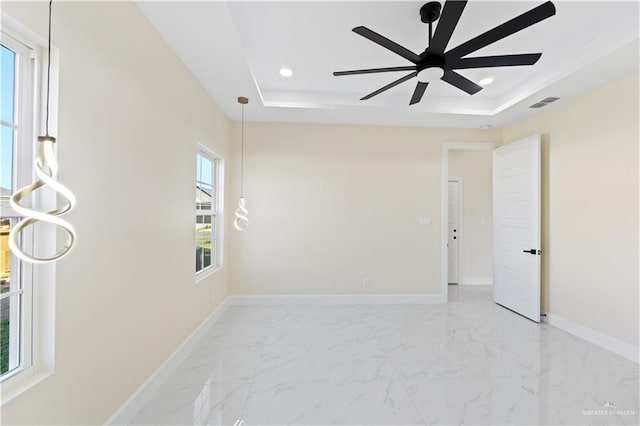 empty room with a tray ceiling and ceiling fan