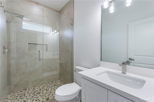 bathroom featuring a shower with door, vanity, and toilet