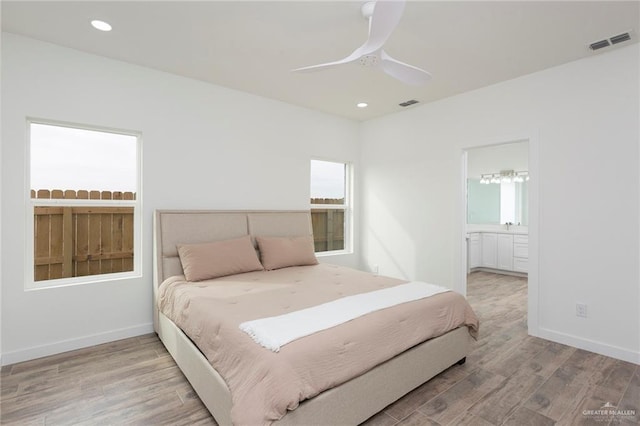 bedroom featuring connected bathroom, ceiling fan, and light wood-type flooring