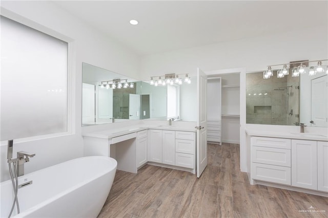 bathroom with independent shower and bath, wood-type flooring, and vanity