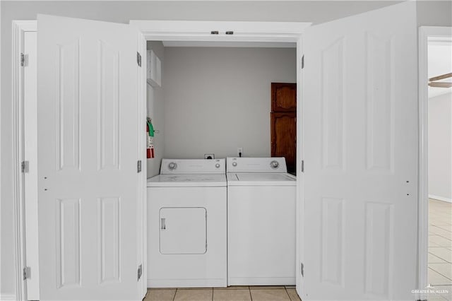 clothes washing area with washer and dryer, laundry area, and light tile patterned flooring