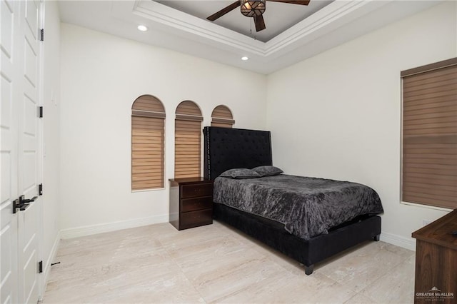 bedroom with ceiling fan and a tray ceiling