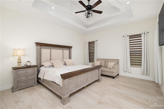 bedroom with a tray ceiling and ceiling fan