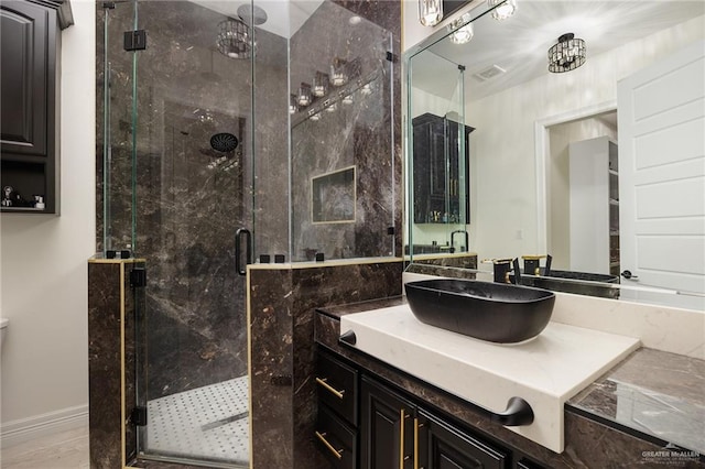 bathroom with a shower with door and vanity