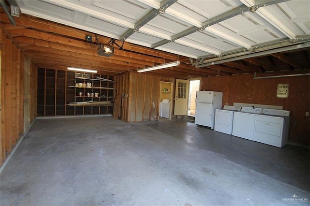 garage with washer and dryer, wooden walls, freestanding refrigerator, and a garage door opener