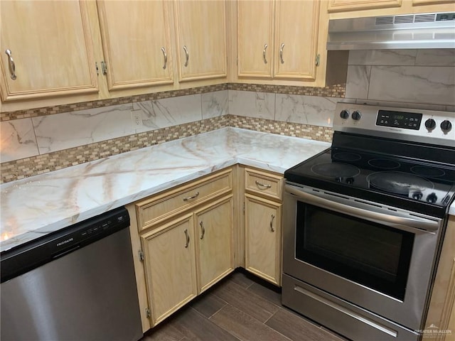 kitchen featuring decorative backsplash, light stone countertops, light brown cabinetry, and appliances with stainless steel finishes