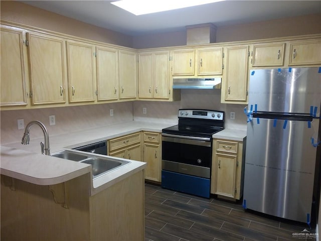 kitchen featuring kitchen peninsula, light brown cabinetry, and stainless steel appliances