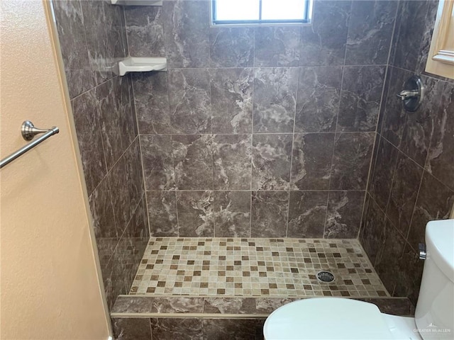 bathroom with tiled shower and toilet