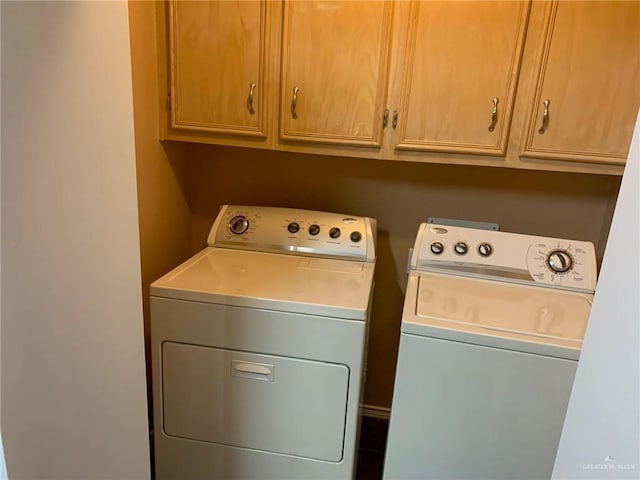 washroom featuring washer and dryer and cabinets