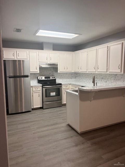 kitchen with light hardwood / wood-style floors, white cabinetry, and appliances with stainless steel finishes