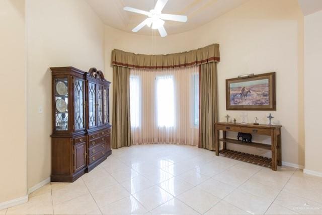 interior space featuring ceiling fan, light tile patterned floors, and high vaulted ceiling