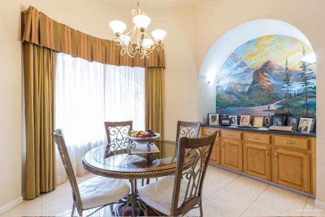 dining area with light tile patterned floors and a notable chandelier