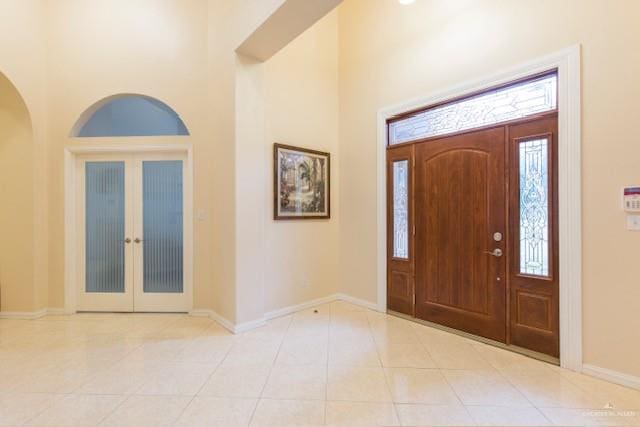 foyer featuring light tile patterned floors and a towering ceiling