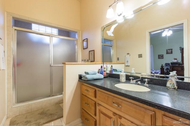 bathroom with vanity, tile patterned floors, ceiling fan, and a shower with shower door