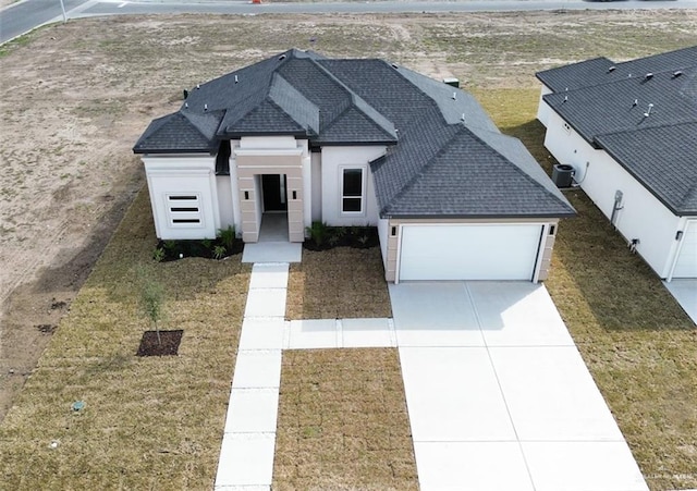 view of front of property featuring cooling unit and a garage