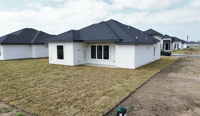 rear view of house featuring a yard