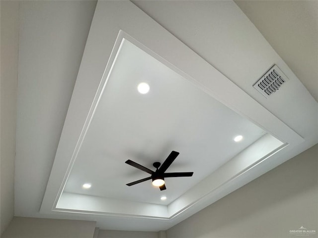 room details featuring ceiling fan and a tray ceiling