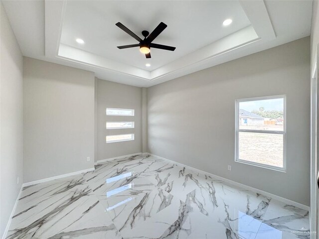 unfurnished room featuring ceiling fan and a tray ceiling