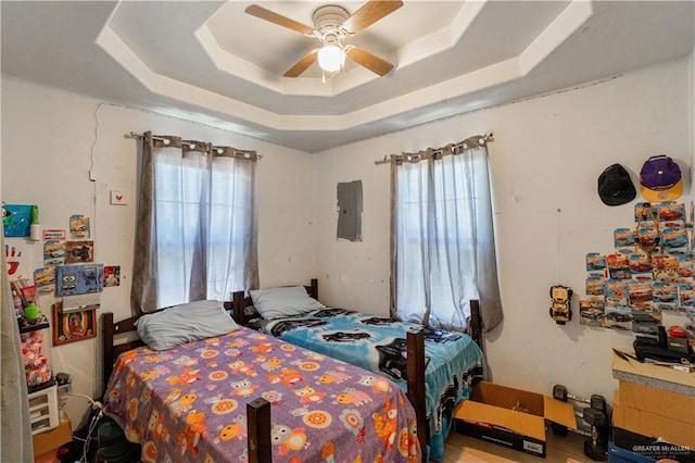 bedroom featuring ceiling fan, electric panel, and a raised ceiling