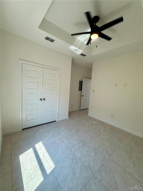 5325 Vision St, Rio Grande City, TX 78582 - unfurnished bedroom featuring a tray ceiling, baseboards, a closet, and ceiling fan