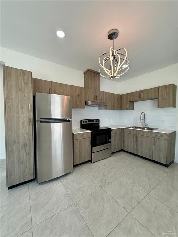 5325 Vision St, Rio Grande City, TX 78582 - kitchen featuring stainless steel appliances, a sink, under cabinet range hood, light countertops, and a chandelier
