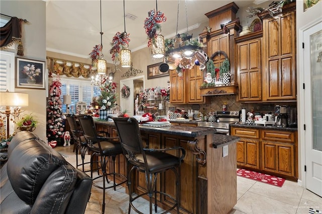 kitchen featuring a kitchen breakfast bar, tasteful backsplash, decorative light fixtures, a center island, and stainless steel range with electric cooktop