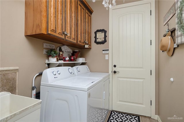 laundry area with sink, cabinets, a notable chandelier, light tile patterned flooring, and washer and dryer