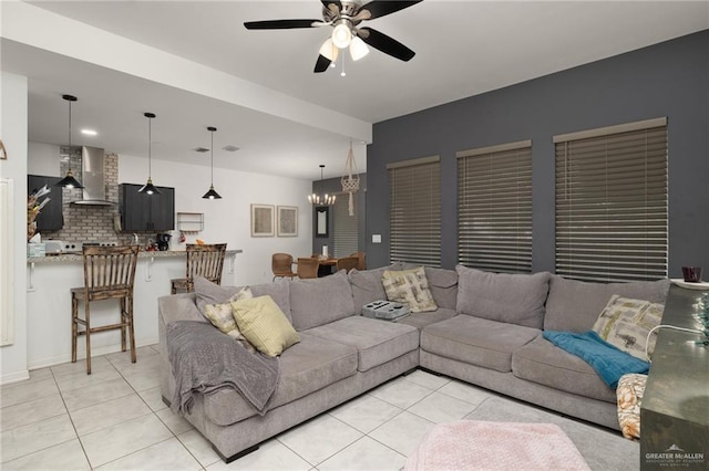 tiled living room featuring ceiling fan with notable chandelier