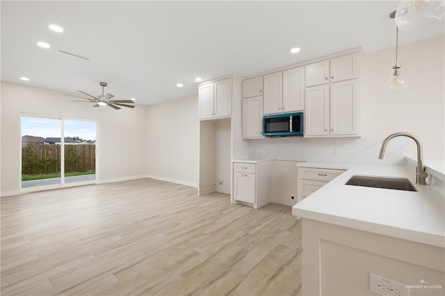 2508 E Solar Dr, Mission, TX 78501 - kitchen featuring a sink, stainless steel microwave, light wood-style floors, ceiling fan, and recessed lighting