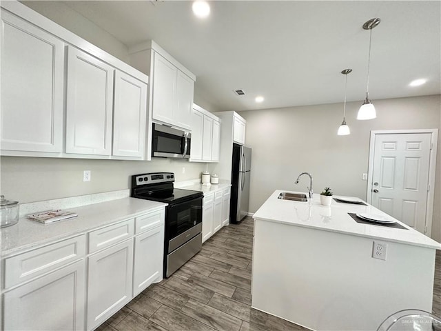 kitchen featuring stainless steel appliances, sink, a center island with sink, and white cabinets