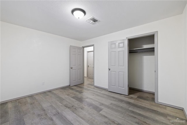 609 E Sprague St, Edinburg, TX 78539 - unfurnished bedroom featuring light wood-style floors, a closet, and a textured ceiling