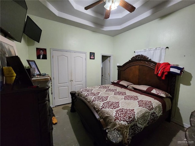 bedroom featuring a closet, a raised ceiling, and ceiling fan