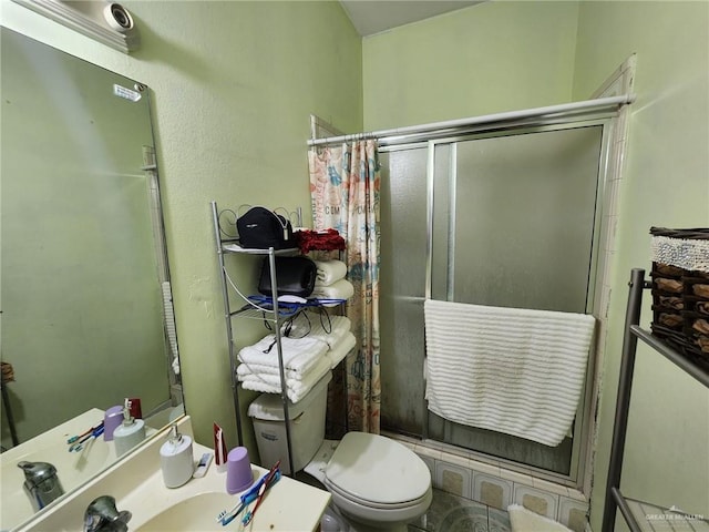 bathroom featuring a shower with shower door and toilet