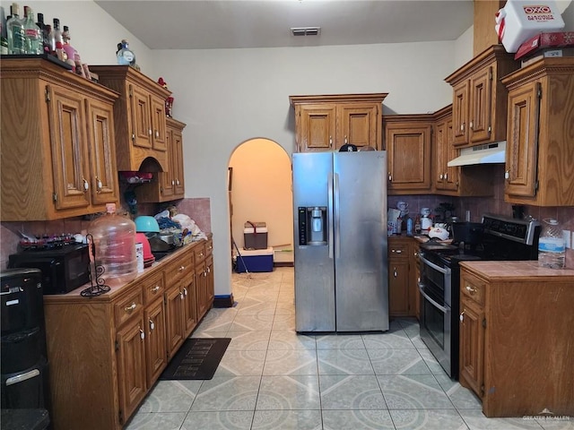 kitchen featuring light tile patterned flooring, appliances with stainless steel finishes, and tasteful backsplash