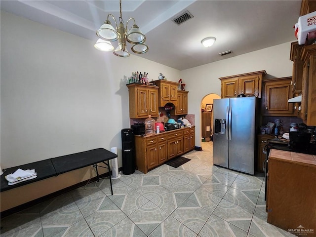 kitchen with stainless steel fridge with ice dispenser, light tile patterned floors, a chandelier, and black range with electric cooktop