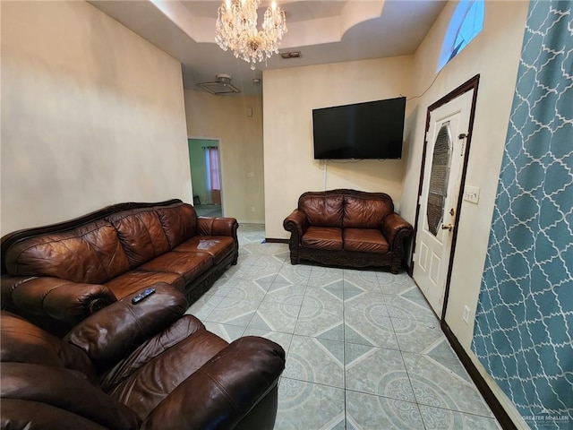 tiled living room with a raised ceiling and a chandelier