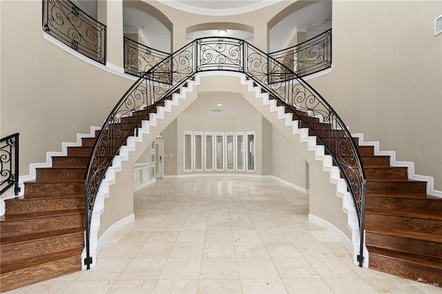 interior space with a high ceiling and crown molding