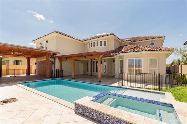 back of property featuring a pool with hot tub, a patio, and ceiling fan