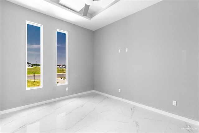 unfurnished room featuring marble finish floor, baseboards, and a ceiling fan